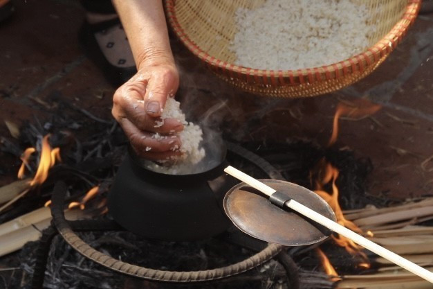 Gạo sau khi được giã xong sẽ đem vo sạch và cho vào nồi nấu cơm. (Ảnh: Minh Quyết/TTXVN)