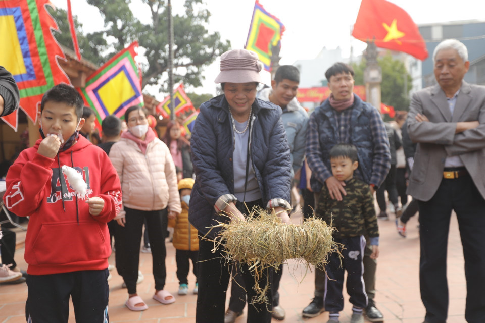 Các đội thi bện rơm, chuẩn bị cho phần thi nấu cơm. (Ảnh: Minh Quyết/TTXVN)