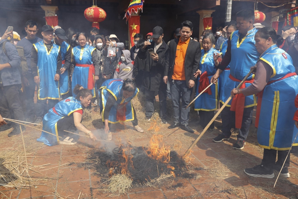 Khi cơm nấu gần xong, các đội sẽ tiến hành đốt rơm thành nhiều đống để giấu và ủ cho cơm chín. (Ảnh: Minh Quyết/TTXVN)