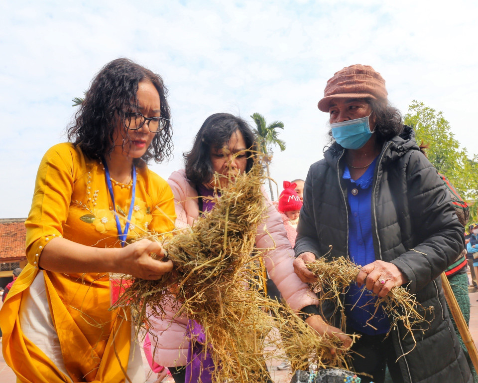 Các đội chọn rơm để bện rồi ủ các nồi cơm. (Ảnh: Tuấn Đức/TTXVN)