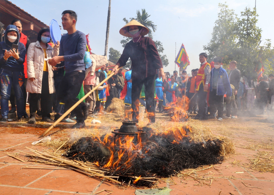 Khi cơm nấu gần xong, các đội sẽ tiến hành đốt rơm thành nhiều đống để giấu và ủ cho cơm chín. (Ảnh: Minh Quyết/TTXVN)