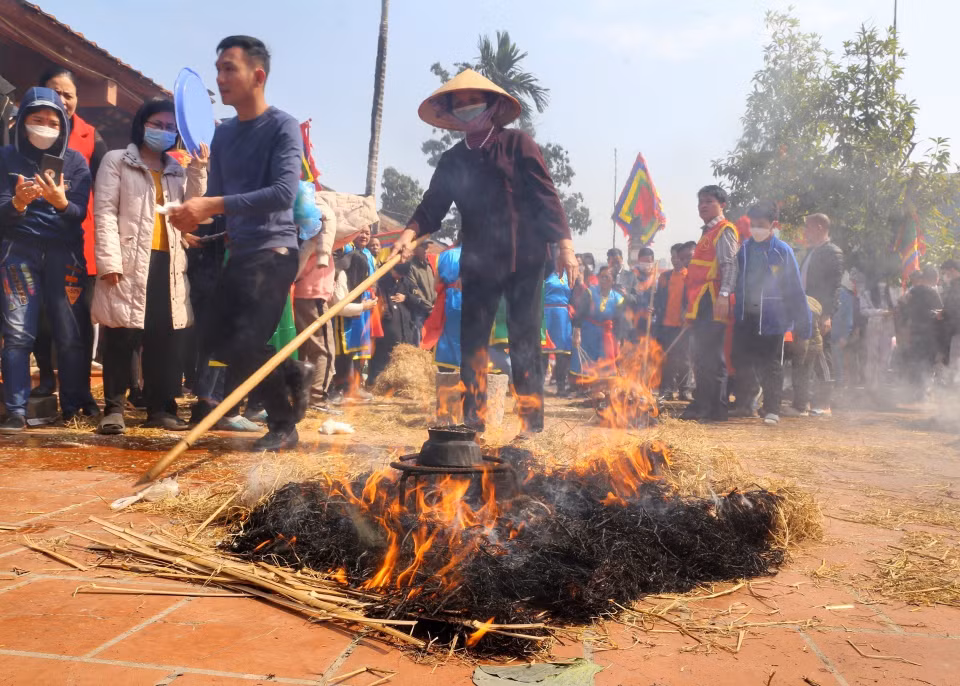 Khi cơm nấu gần xong, các đội sẽ tiến hành đốt rơm thành nhiều đống để giấu và ủ cho cơm chín. (Ảnh: Minh Quyết/TTXVN)