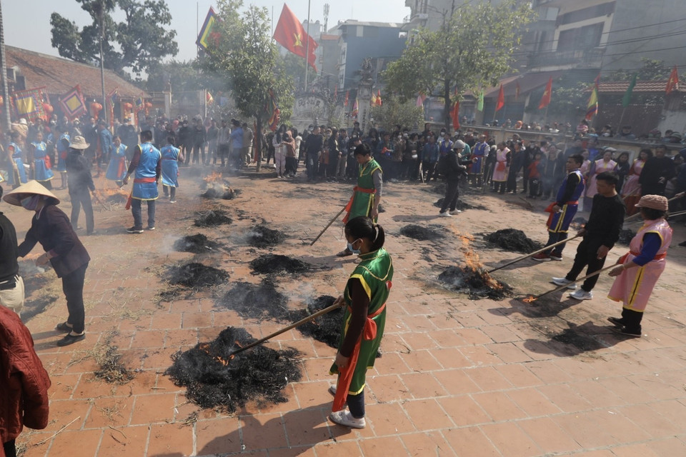 Khi cơm nấu gần xong, các đội sẽ tiến hành đốt rơm thành nhiều đống để giấu và ủ cho cơm chín. (Ảnh: Minh Quyết/TTXVN)