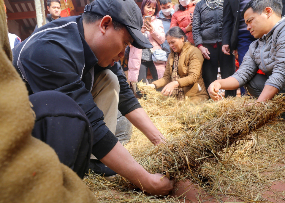 Các đội bện rơm để ủ các nồi cơm sao cho chín đều. (Ảnh: Tuấn Đức/TTXVN)