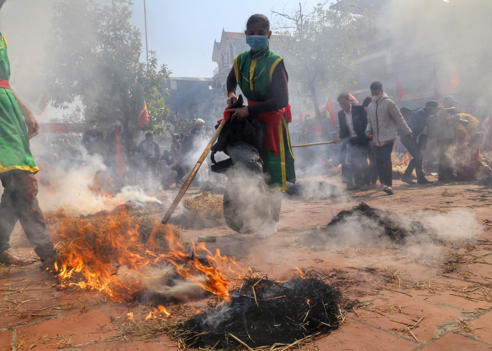 Khi cơm nấu gần xong, các đội sẽ tiến hành đốt rơm thành nhiều đống để giấu và ủ cho cơm chín. (Ảnh: Minh Quyết/TTXVN)