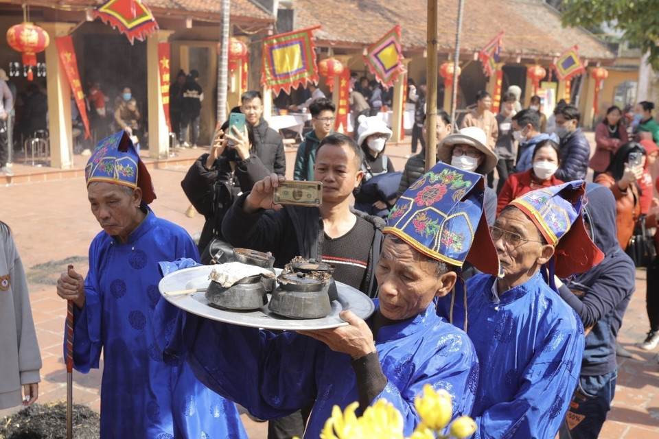 Sau khoảng thời gian ủ, ban giám khảo sẽ đi tìm các nồi cơm được giấu trong đống tro và mang về chấm. (Ảnh: Minh Quyết/TTXVN)