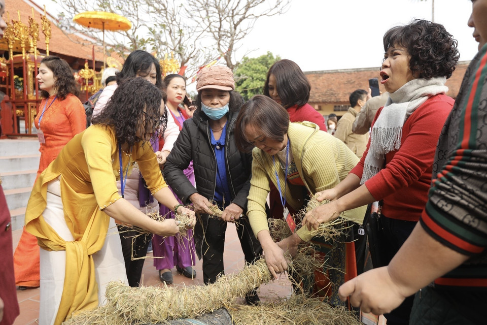 Các đội thi bện rơm, chuẩn bị cho phần thi nấu cơm. (Ảnh: Minh Quyết/TTXVN)