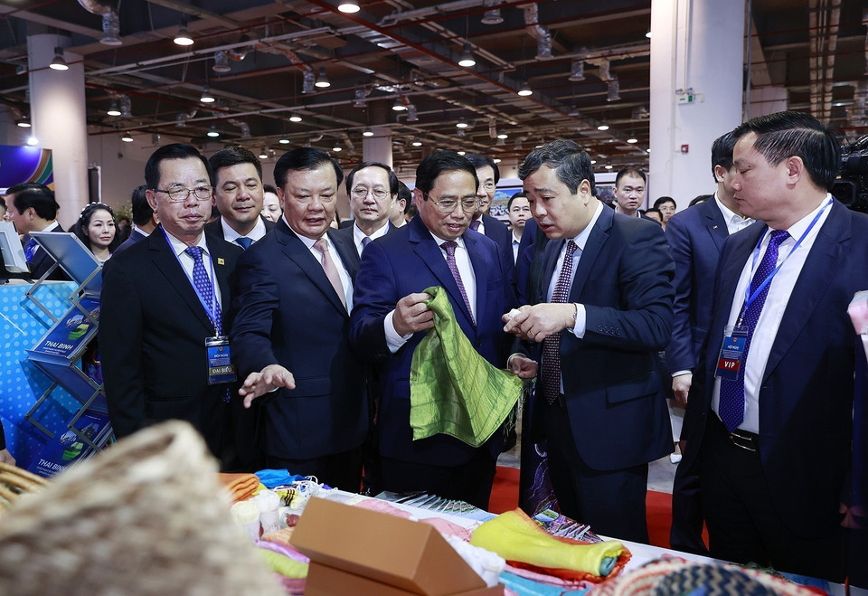 Thủ tướng Phạm Minh Chính xem trưng bày sản phẩm thủ công, mỹ nghệ của các làng nghề ở tỉnh Đồng bằng sông Hồng. (Ảnh: Dương Giang/TTXVN)