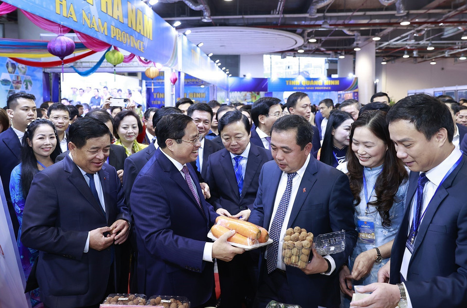Thủ tướng Phạm Minh Chính xem trưng bày sản phẩm nông nghiệp. (Ảnh: Dương Giang/TTXVN)