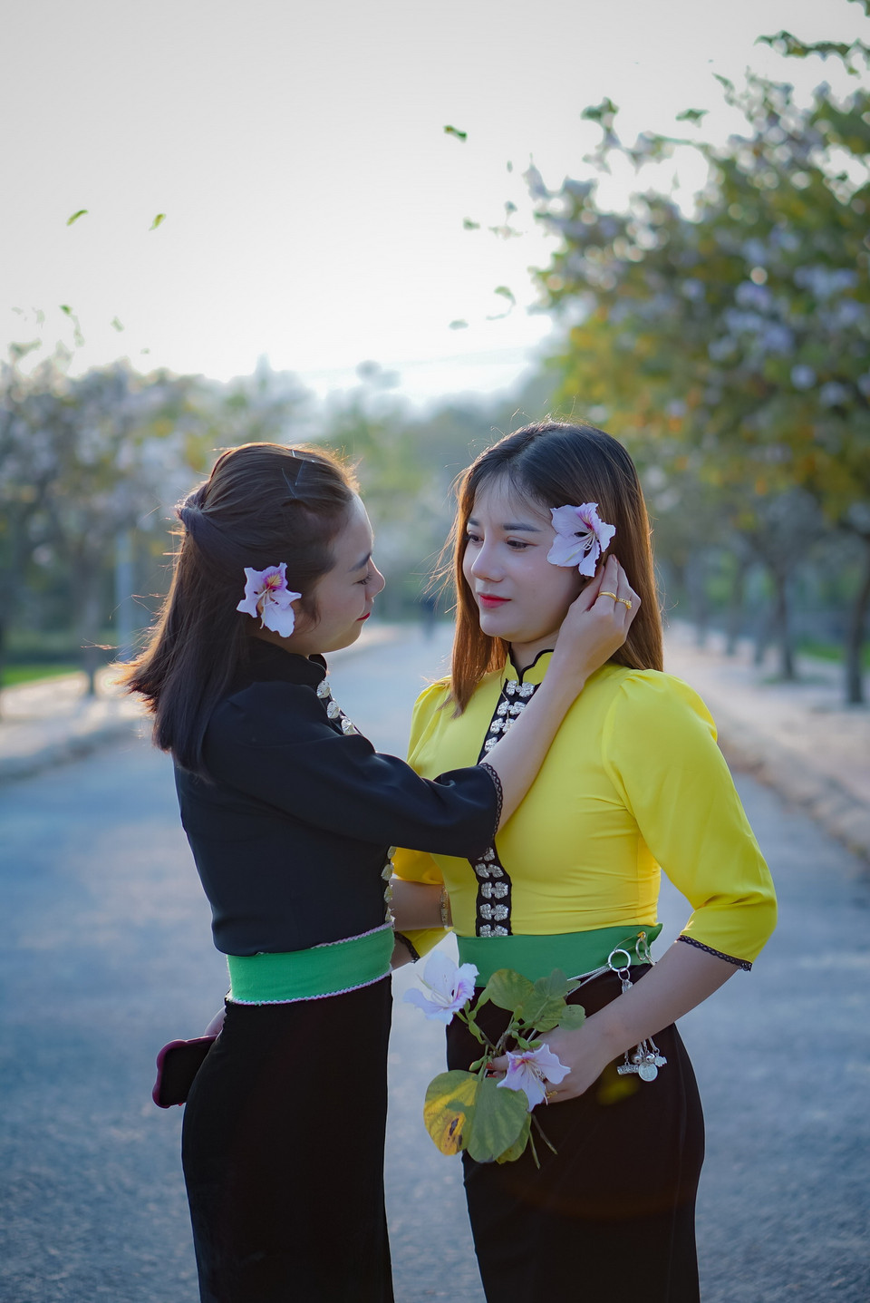 Thiếu nữ trong bộ áo cóm dân tộc Thái tạo dáng với hoa ban. (Ảnh: Xuân Tư/TTXVN)