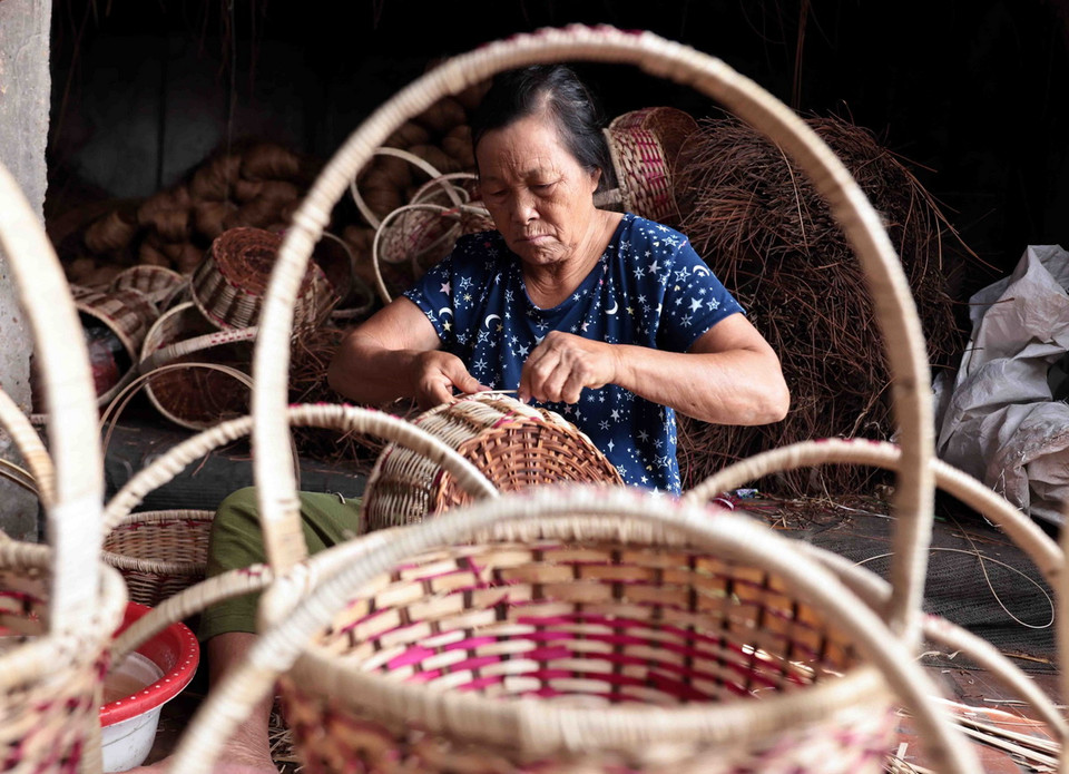 Nghệ nhân làng nghề mây tre đan Phúc Túc đang sản xuất những giỏ đựng hàng. (Ảnh: Trần Việt/TTXVN)
