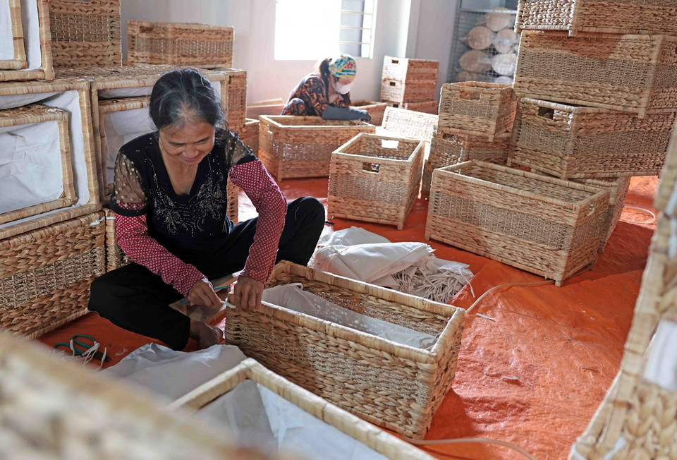 Công ty TNHH Phúc Thịnh ở làng nghề Phú Túc chuyên thu mua, sản xuất hàng xuất khẩu, thu hút hàng chục lao động. (Ảnh: Trần Việt/TTXVN)