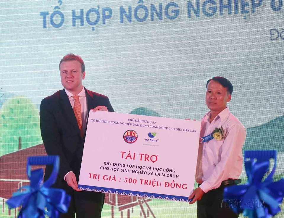 Đại diện Tập đoàn De Heus (Hà Lan) - chủ đầu tư Dự án “Tổ hợp Nông nghiệp ứng dụng Công nghệ cao DHN Đắk Lắk” tặng học bổng và tài trợ xây dựng lớp học cho học sinh nghèo xã Ea M’droh, huyện Cư M’gar, tỉnh Đắk Lắk. (Ảnh: Tuấn Anh/TTXVN)
