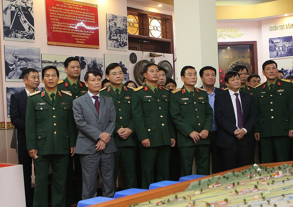 Tổng Giám đốc TTXVN Nguyễn Đức Lợi cùng các thành viên trong đoàn thăm Phòng truyền thống của Sư đoàn 325. (Ảnh: Dương Giang/TTXVN)