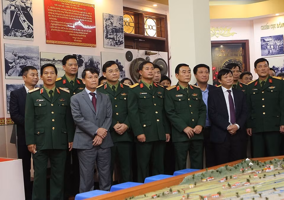 Tổng Giám đốc TTXVN Nguyễn Đức Lợi cùng các thành viên trong đoàn thăm Phòng truyền thống của Sư đoàn 325. (Ảnh: Dương Giang/TTXVN) 