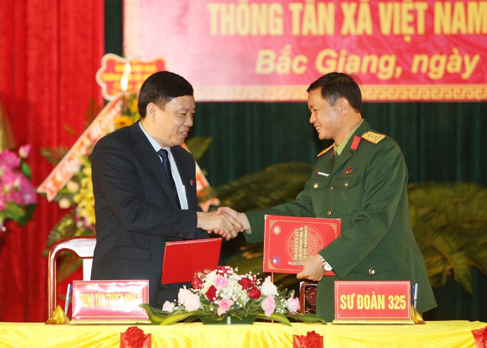 Giám đốc Truyền hình Thông tấn Nguyễn Thiện Thuật và Thượng tá Nguyễn Thành Phố, Sư đoàn trưởng Sư đoàn 325 ký biên bản kết nghĩa. (Ảnh: Dương Giang/TTXVN)