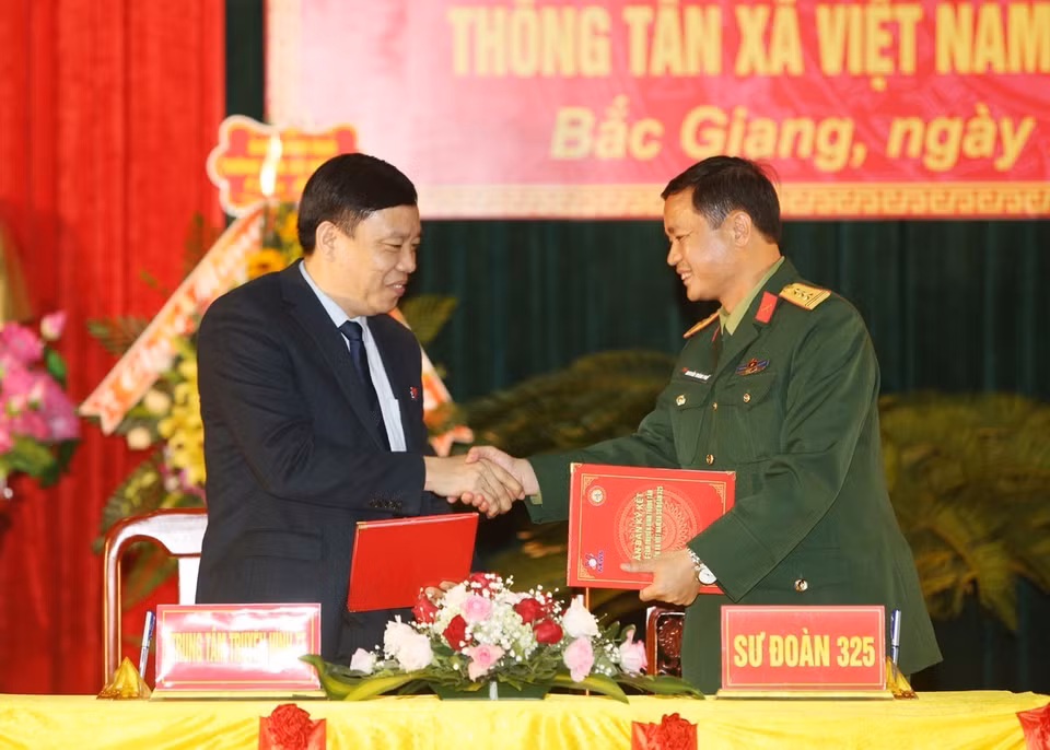 Giám đốc Truyền hình Thông tấn Nguyễn Thiện Thuật và Thượng tá Nguyễn Thành Phố, Sư đoàn trưởng Sư đoàn 325 ký biên bản kết nghĩa. (Ảnh: Dương Giang/TTXVN)