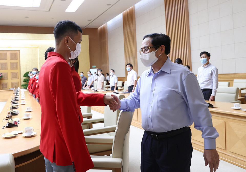  Thủ tướng Phạm Minh Chính với các vận động viên Đoàn Thể thao Việt Nam tham dự Olympic Tokyo 2020 tại Nhật Bản. (Ảnh: Dương Giang/TTXVN)