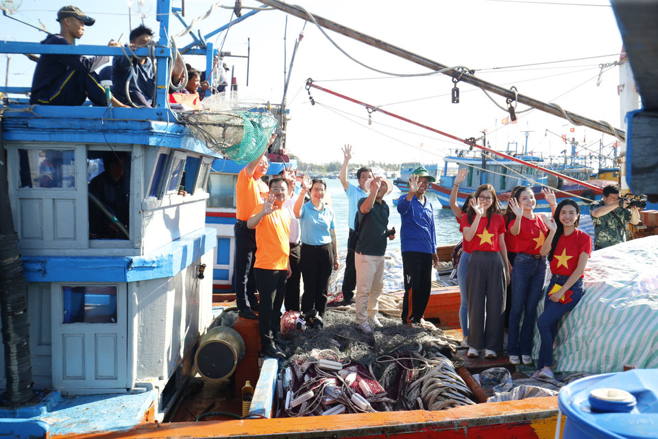 Ban Tổ chức vẫy chào một con tàu ra khơi ngay sau khi được thay Quốc kỳ mới. (Ảnh: Tùng Lâm/Vietnam+)