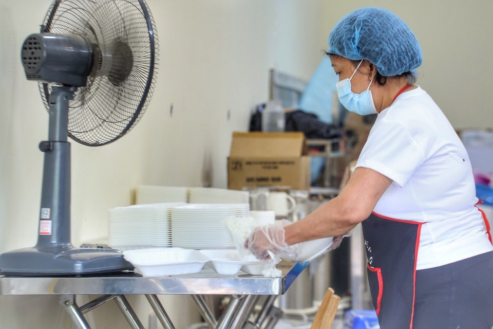 Mỗi người một tay để chuẩn bị những suất cơm miễn phí. (Ảnh: Tuấn Đức/TTXVN)