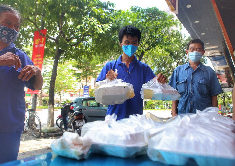 Khoảng 11h hàng ngày, người lao động có hoàn cảnh khó khăn sẽ đến nhận cơm. (Ảnh: Tuấn Đức/TTXVN)