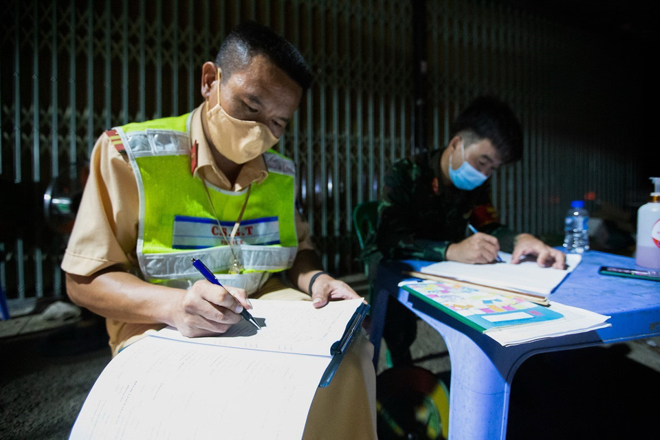  Lực lượng chức năng ghi chép tỉ mỉ toàn bộ thông tin về người và xe lưu thông vào địa phận tỉnh Hòa Bình. (Ảnh: Trọng Đạt/TTXVN)