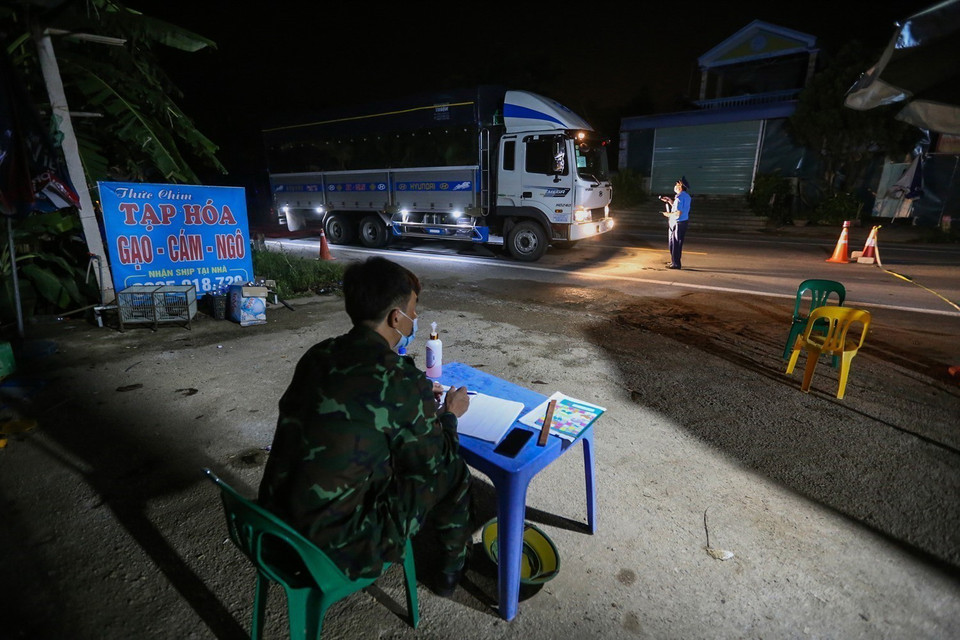  Lực lượng chức năng thực hiện kiểm soát người và phương tiện trong đêm lưu thông qua chốt. (Ảnh: Trọng Đạt/TTXVN)