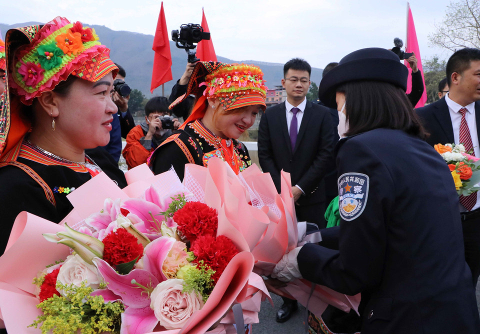 Phía Trung Quốc tặng hoa cho cho người dân Việt Nam xuất cảnh tại khu vực cửa khẩu quốc tế Ma Lù Thàng (Lai Châu, Việt Nam)-Kim Thủy Hà (Trung Quốc). (Ảnh: Nguyễn Oanh/TTXVN)