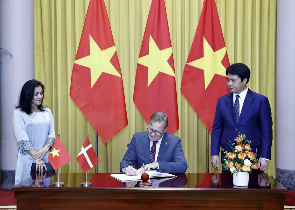 Đại sứ Vương quốc Đan Mạch Nicolai Prytz viết lưu bút. (Ảnh: Thống Nhất/TTXVN)