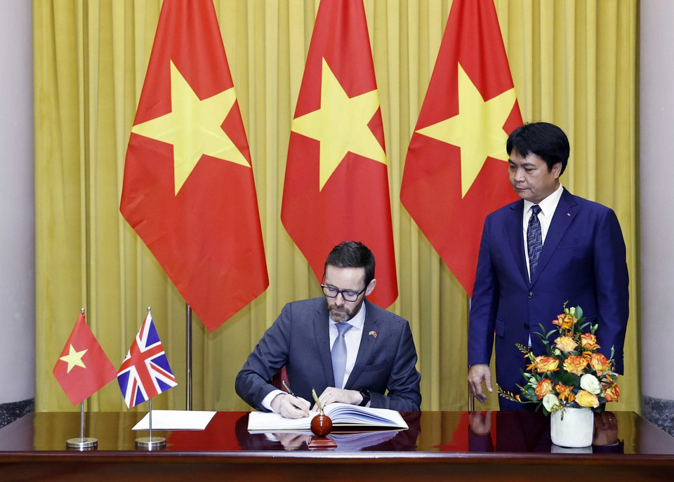 Đại sứ Liên hiệp Vương quốc Anh và Bắc Ireland Iain Frew viết lưu bút. (Ảnh: Thống Nhất/TTXVN)