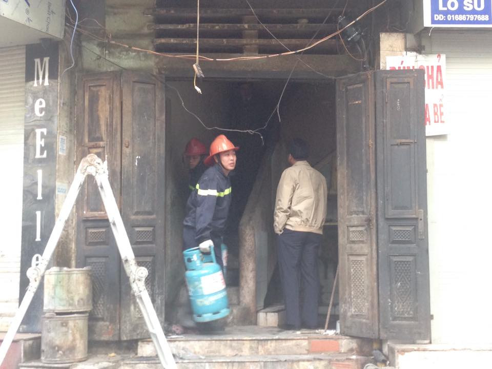 Lính cứu hỏa chuyển đồ xuống ngôi nhà đang có người "cố thủ." (Ảnh: Việt Phương/Vietnam+)