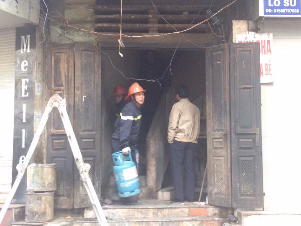 Lính cứu hỏa chuyển đồ xuống ngôi nhà đang có người "cố thủ." (Ảnh: Việt Phương/Vietnam+)