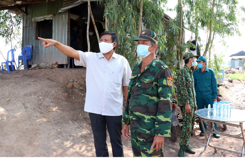  Ông Võ Anh Huy, Phó Bí thư Thường trực Huyện ủy Đức Huệ, Long An (trái) trao đổi tình hình phòng dịch với chiến sỹ Chốt phòng dịch Kênh Trường Hát, xã Mỹ Quý Tây, Đức Huệ. (Ảnh: Xuân Khu/TTXVN)