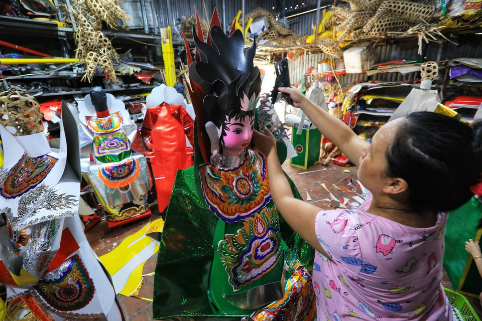 Chăm chút dán và ghép sản phẩm vàng mã. (Ảnh: Thành Đạt/TTXVN)