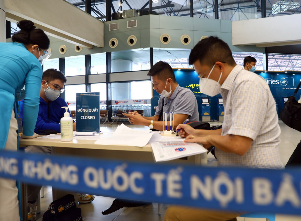 Trước khi vào làm thủ tục, hành khách phải thực hiện khai báo y tế và ký bản cam kết phòng chống dịch COVID-19. (Ảnh: Huy Hùng/TTXVN)