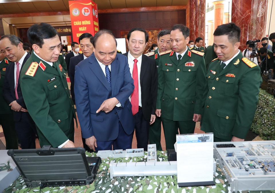 Chủ tịch nước Nguyễn Xuân Phúc và các đại biểu tham quan trưng bày sản phẩm khoa học, công nghệ lĩnh vực quân sự, quốc phòng. (Ảnh: Trọng Đức/TTXVN)