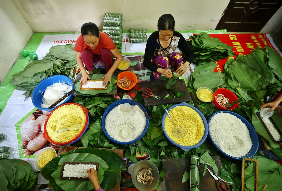 Những người thợ gói bánh chưng tại hộ gia đình bà Lành, Liên Xá, Đông Anh. (Ảnh: Minh Quyết/TTXVN)