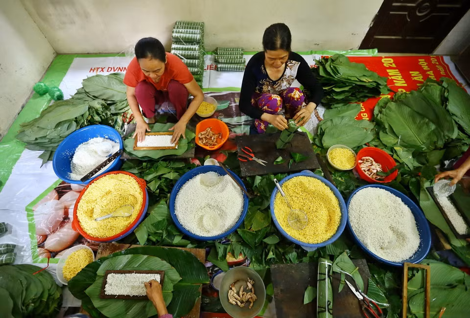 Những người thợ gói bánh chưng tại hộ gia đình bà Lành, Liên Xá, Đông Anh. (Ảnh: Minh Quyết/TTXVN)