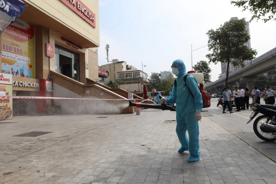  Lực lượng y tế quận Hà Đông tiến hành phun khử khuẩn 2 tòa chung cư bị phong tỏa sáng 13/5. (Ảnh: Thành Đạt/TTXVN)