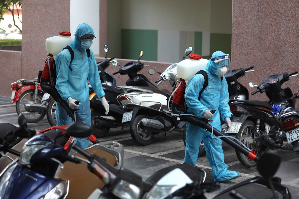  Lực lượng y tế quận Hà Đông tiến hành phun khử khuẩn 2 tòa chung cư bị phong tỏa sáng 13/5. (Ảnh: Thành Đạt/TTXVN)