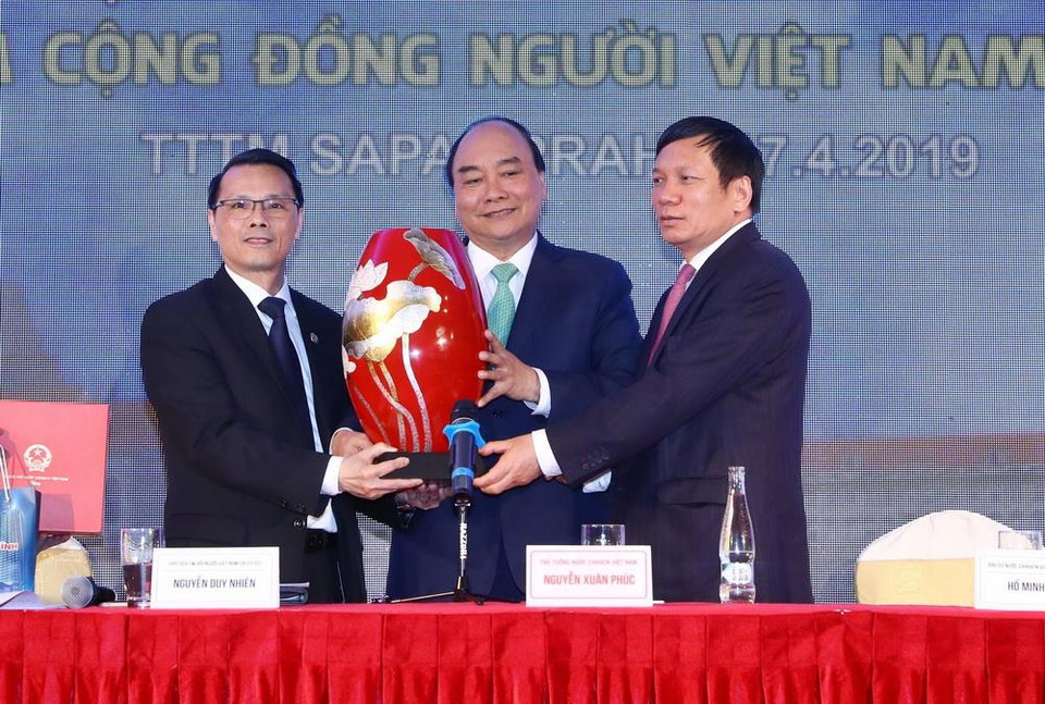 Thủ tướng Nguyễn Xuân Phúc tặng quà cho cộng đồng người Việt Nam tại Séc. (Ảnh: Thống Nhất/TTXVN)