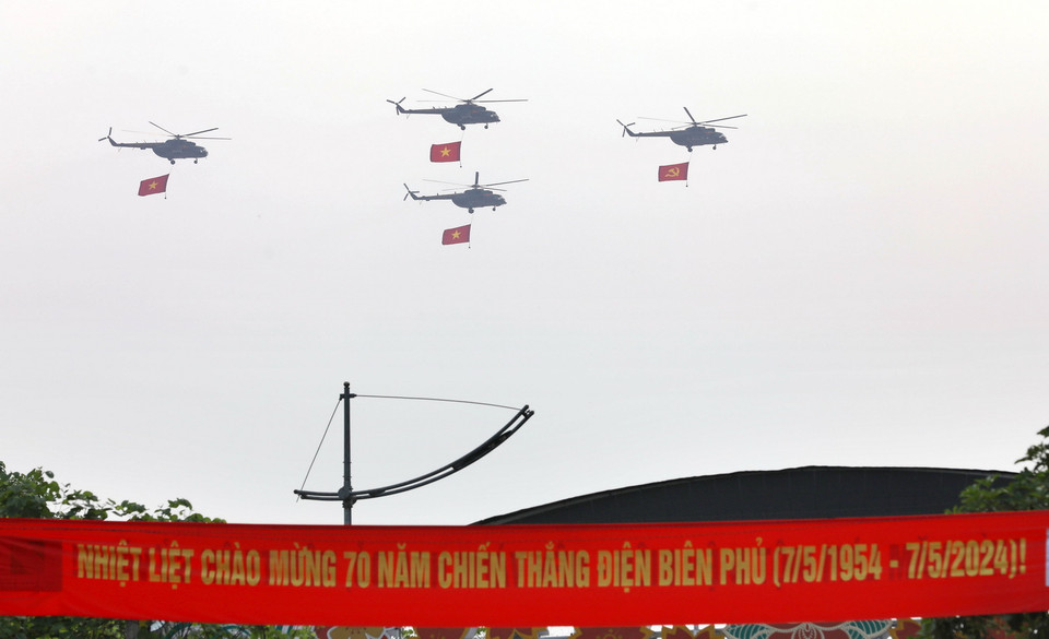 Những chiếc trực thăng của lực lượng Không quân mang theo cờ Đảng, cờ Tổ quốc bay trên bầu trời Điện Biên. (Ảnh: Trung Kiên/TTXVN)