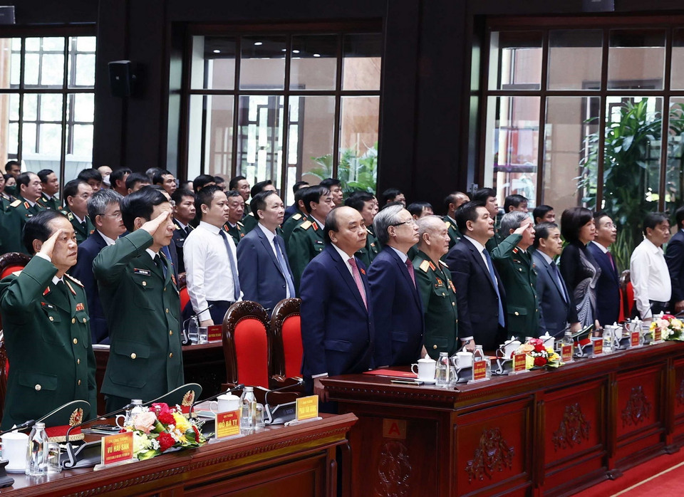 Chủ tịch nước Nguyễn Xuân Phúc cùng các đại biểu thực hiện nghi lễ chào cờ. (Ảnh: Thống Nhất/TTXVN)