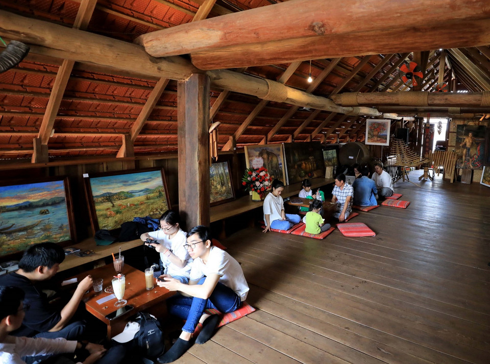 Du khách thưởng thức càphê trong không gian nhà dài truyền thống của người Ê Đê. (Ảnh: Nhật Anh/TTXVN)