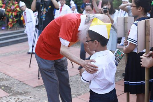 Thầy Văn Như Cương đón em học sinh mới (lớp 6 ). (Ảnh: Tùng Lâm/Vietnam+)