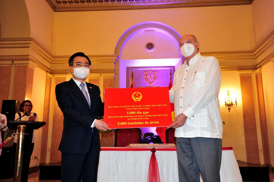 Bộ trưởng Bộ Xây dựng Nguyễn Thanh Nghị trao tượng trưng cho Bộ trưởng Ngoại thương và Đầu tư nước ngoài Cuba Rodrigo Malmierca Díaz món quà 5.000 tấn gạo của Nhà nước và nhân dân Việt Nam tặng nhân dân Cuba (2021). (Ảnh: Lê Hà/TTXVN)