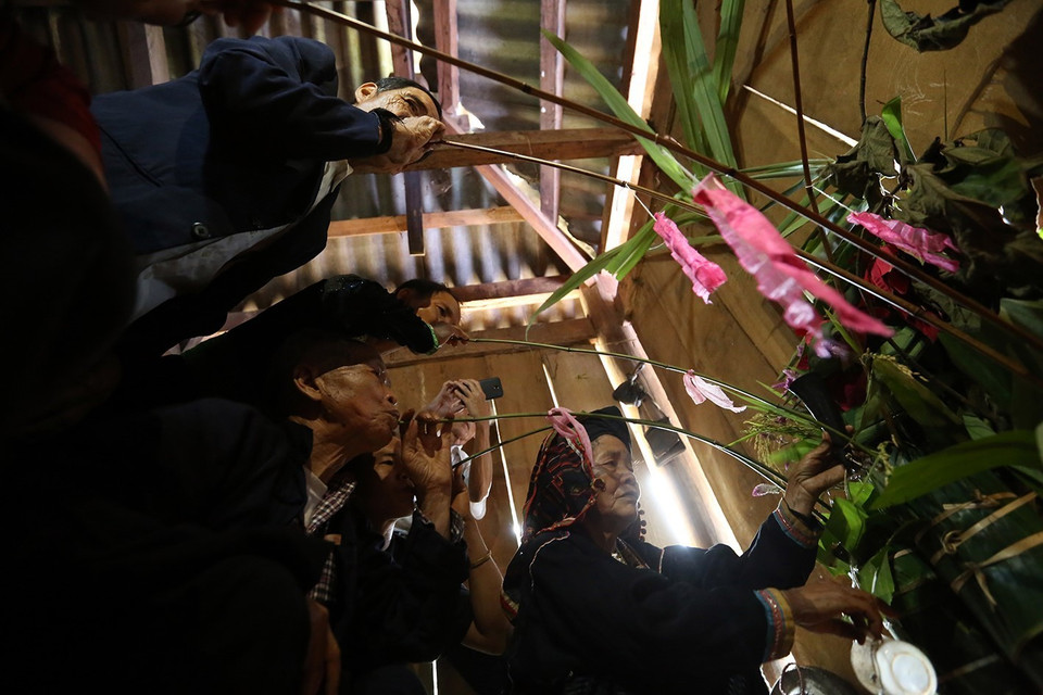 Sau khi cúng mời tổ tiên, các con cháu uống rượu cần mời ông bà về chung vui với dòng họ. (Ảnh: Pha Tuấn Anh/TTXVN)