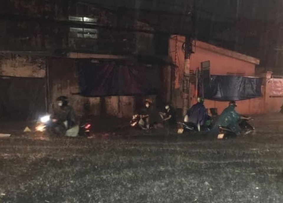 Người dân “ngụp lặn” giữa dòng nước trên đường Phan Anh, quận Bình Tân. (Ảnh: Hồng Giang/TTXVN)