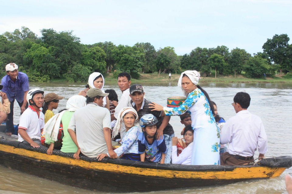 Đồng bào Chăm qua sông đến làm lễ cúng tại khu mộ tổ tiên. (Ảnh: Nguyễn Thanh/TTXVN)