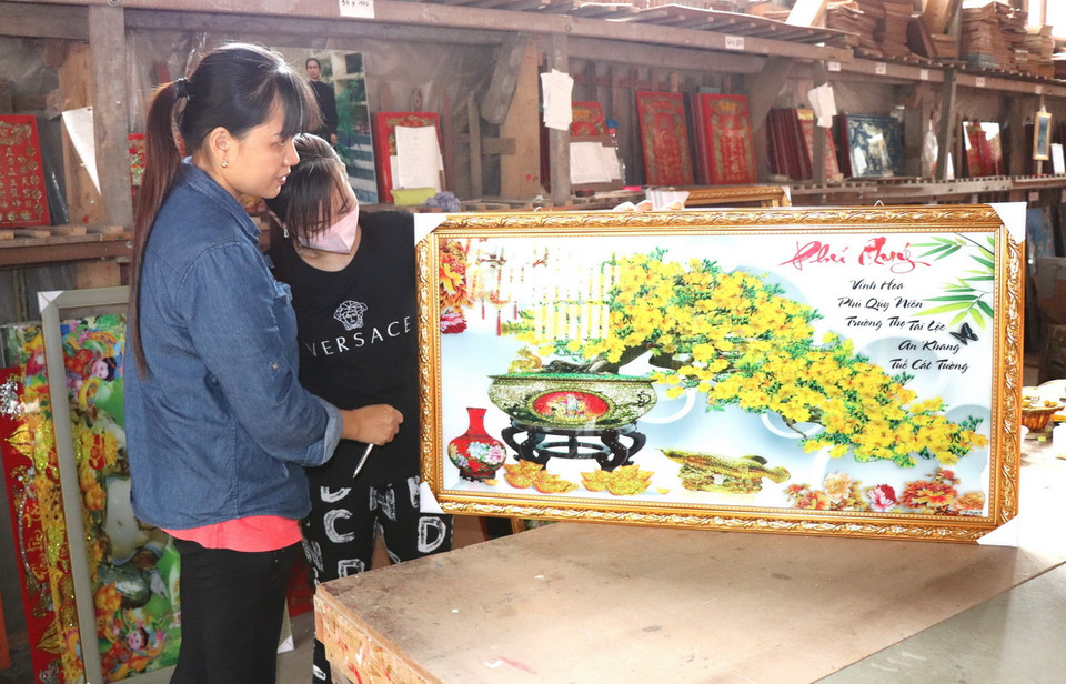 Làng nghề tranh vẽ kiếng (vẽ tranh trên kính) ở huyện Chợ Mới là một trong những làng nghề truyền thống lâu đời nhất ở An Giang. Trong ảnh: Bức tranh kính mai vàng Phú Quý vừa được lên khung. (Ảnh: Thanh Sang/TTXVN)